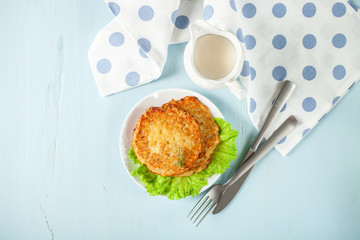 Potato pancakes with salad on a blue background. Rösti . Swiss national dish. Top view