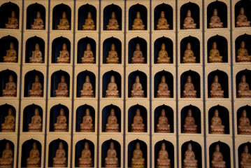 small many Buddha statue used as amulet on the temple wall. Interior Design in temple  Buddhism Religion concept in Asia