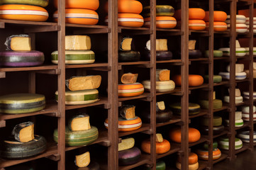 Wooden stand with different kinds of delicious cheese in shop