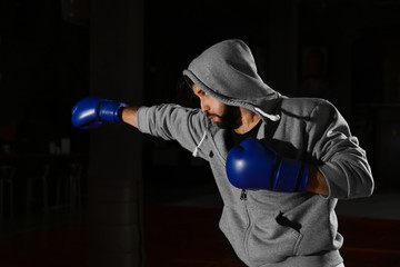 Young professional boxer training in gym