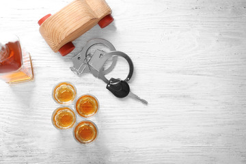 Composition with alcohol, toy and car key on wooden table. Don't drink and drive concept