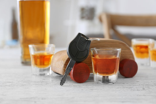 Composition with alcohol, toy and car key on wooden table. Don't drink and drive concept