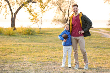 Fototapeta premium Father and little son with rugby ball outdoors