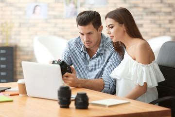 Young photographers with camera in office