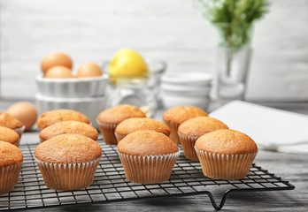Cooling rack with delicious cupcakes on table, closeup