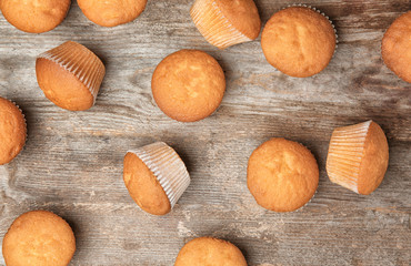 Delicious cupcakes on wooden background, top view