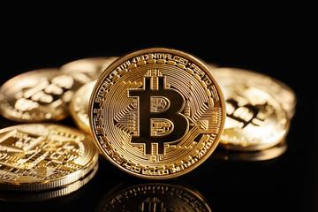 Golden bitcoins on black background