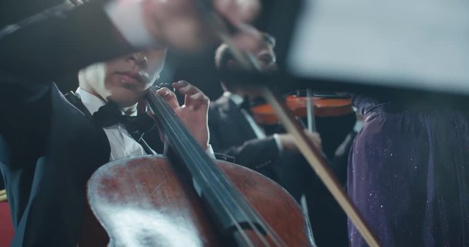 string quartet performs on stage, close-up Asian cellist playing classical music