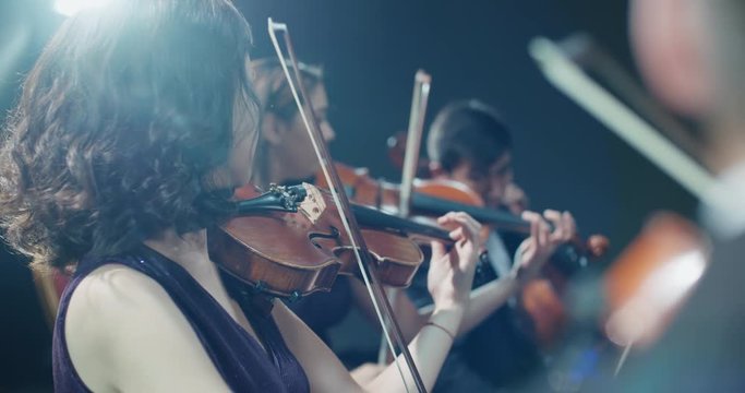 string quartet performs on stage, close-up of violin in work
