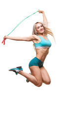 Full length image of a young sports woman jumping on skipping rope over white background
