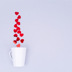 White china mug with  glitter heart confetti. Valentine day concept. Trendy minimalistic flat lay design background