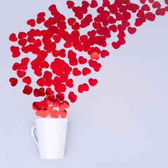 White china mug with  glitter heart confetti. Valentine day concept. Trendy minimalistic flat lay...