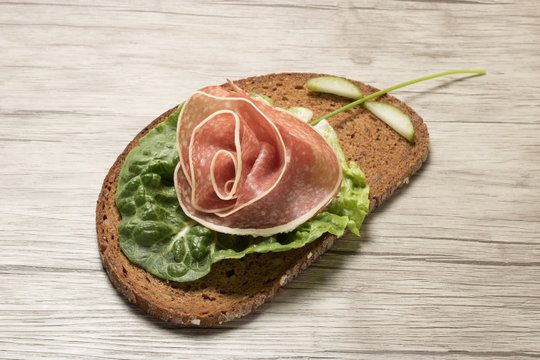 Creative sandwich made with slices of sausage and salad