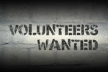 volunteers wanted exclamation stencil print on the grunge white brick wall