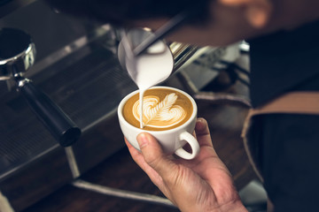 Fototapeta na wymiar Barista making Rosetta shape latte art coffee