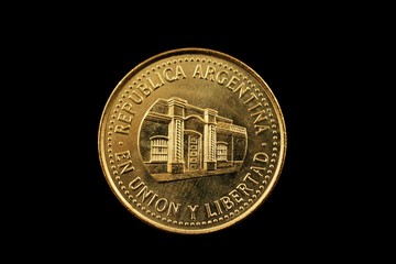 A super macro image of a gold argentinian fifty centavo coin isolated on a black background