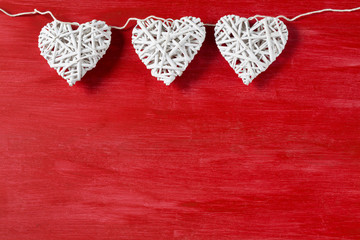 on a red wooden background three white hearts