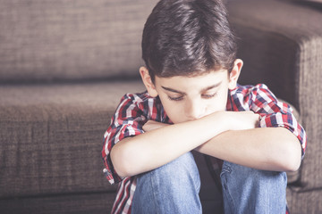 Sad kid lost in his thoughts. Depression concept