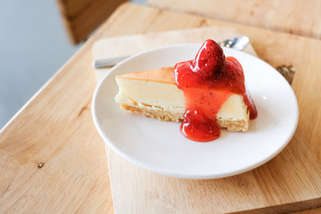 Closeup of cheesecake with strawberry sauce in the cafe.