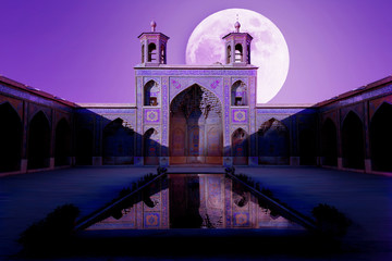 Colorful Mosque Nasir al Mulk in Shiraz against moon sky. Reflection in water.