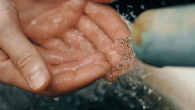 Water pours into man's hands
