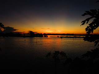 Fototapeta na wymiar Sun going down over the Mekong in flood 