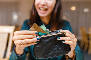 Woman takes the credit card out of wallet in restaurant