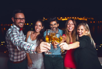 Group of people having a party on the roof, cheering with champagne  