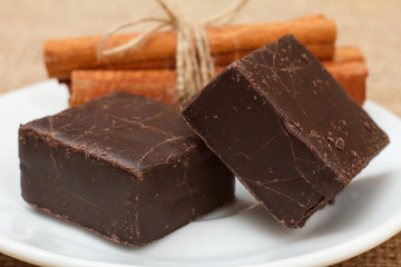 Chocolate candies rectangular shape put on white plate with cinnamon