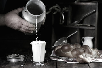 мужчина наливает молоко в стакан 
