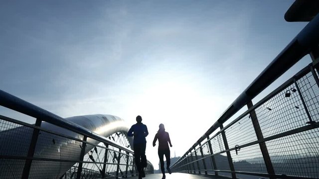 Silhouette of joggers running on bridge in city, super slow motion 240fps
