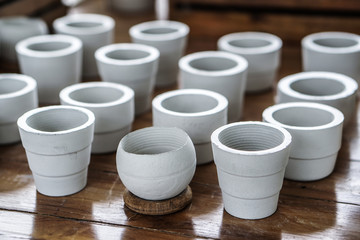 white clay ceramic planting pots on wooden table