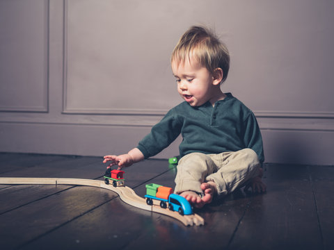 Cute little boy playing with wooden train