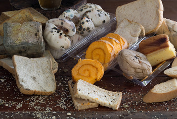 Pile of withered bread and rot on old wooden background and wooden wall which has light splash