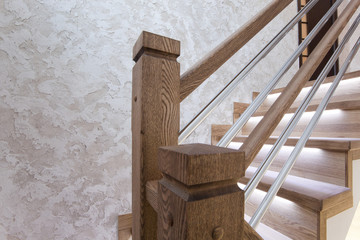 Столбы дубовой лестницы и декоративное покрытие стены