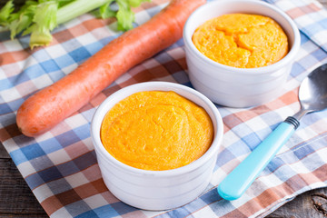 Casserole with tasty carrot souffle on wooden table.