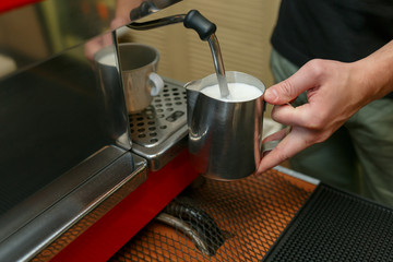 Barista makes coffees in bar. Latte preparation in coffee machine. Hands bartender cooking coffee, preparation milk for latte coffee.