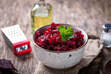 Bowl of beetroot salad on wooden background