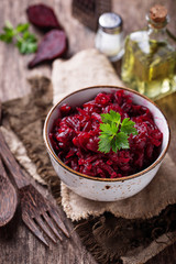 Bowl of beetroot salad on wooden background