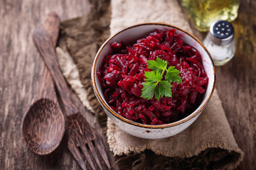 Bowl of beetroot salad on wooden background