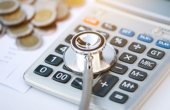 stethoscope and calculator on bills for finance plan or health insurance.