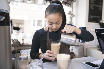 Woman preparing coffee in cafe
