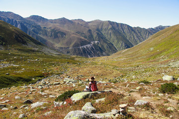 Naklejka premium woman with hat sitting on a stone and resting while watching around