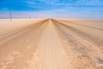 Endless straight sand and gravel roads crossing the Namib desert, Namibia