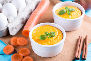 French baked cheese souffle with carrots in white ramekin
