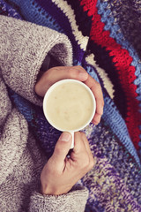 ill man warming up with a cup of soup