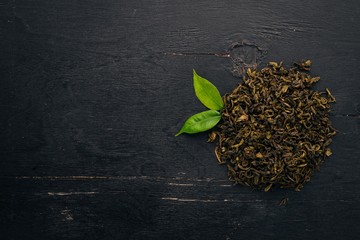 Dry green tea. On a wooden background. Top view. Copy space.