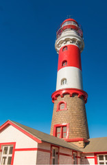 Obraz premium Colonial-era lighthouse in Swakopmund (Mouth of the Swakop), at the edge of Namib desert on the Atlantic ocean coast of western Namibia, capital of the Erongo district.