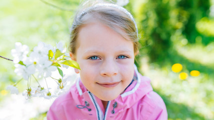 little laughing girl squinting eyes on a spring background