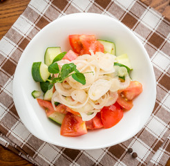olive oil pouring into bowl of salad